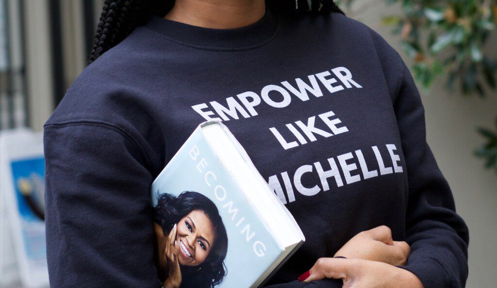 Chica sujeta bajo el brazo el libro "Becoming" de Michelle Obama.